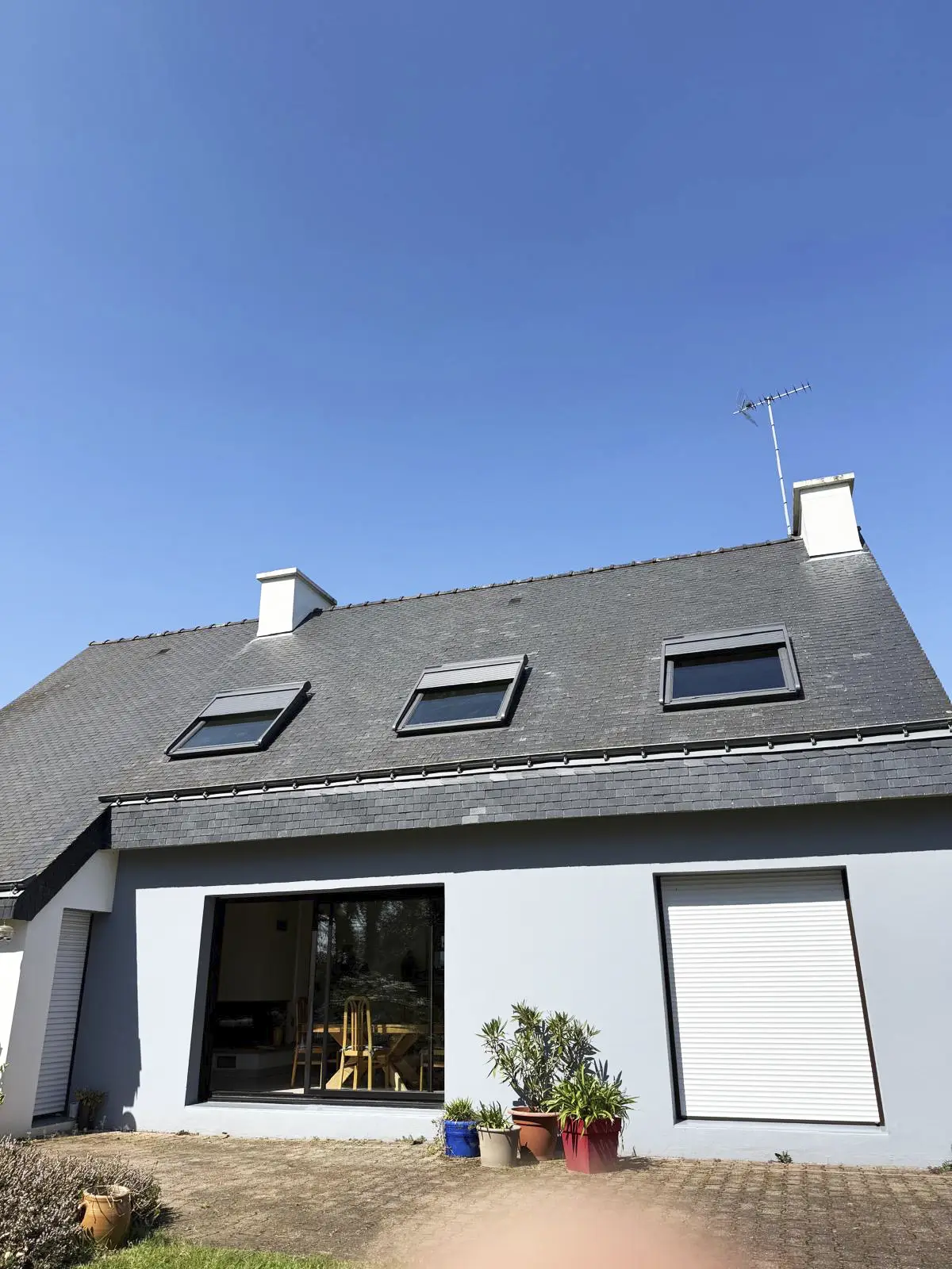 Maison moderne à Baud avec une toiture en ardoise neuve et trois fenêtres de toit de type Velux bien intégrées.