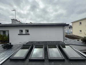 Installation et étanchéité de quatre fenêtres de toit Velux sur une toiture en zinc à Plouay.